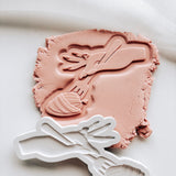 Engaged hand twirling pasta on fork stamp and cutter