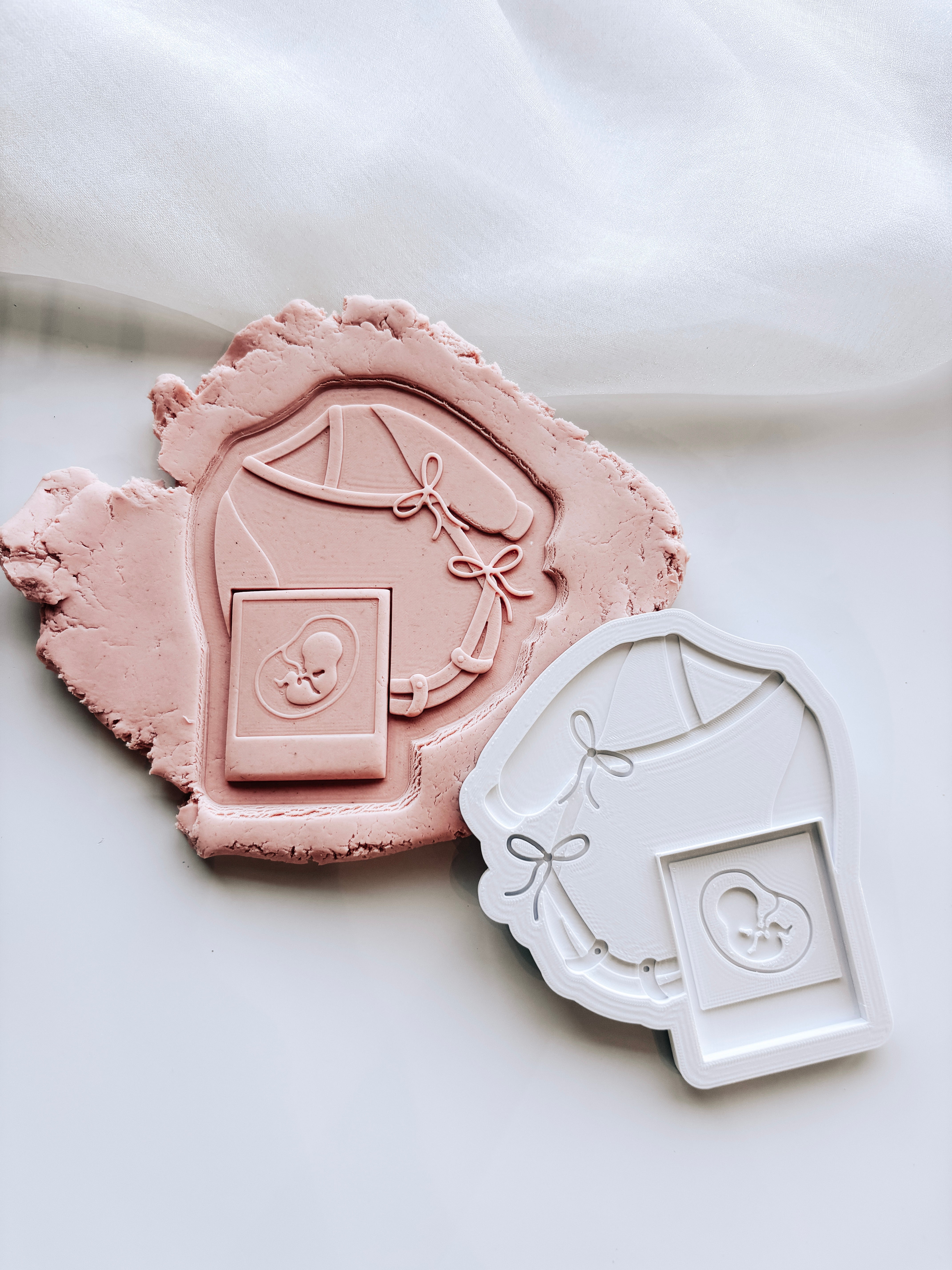 Long sleeved tied baby onesie with sonogram photo stamp and cutter