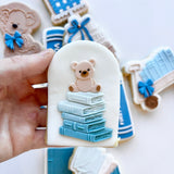 Stack of books with teddy on top stamp and cutter