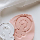 Female symbol with hand stamp and cutter