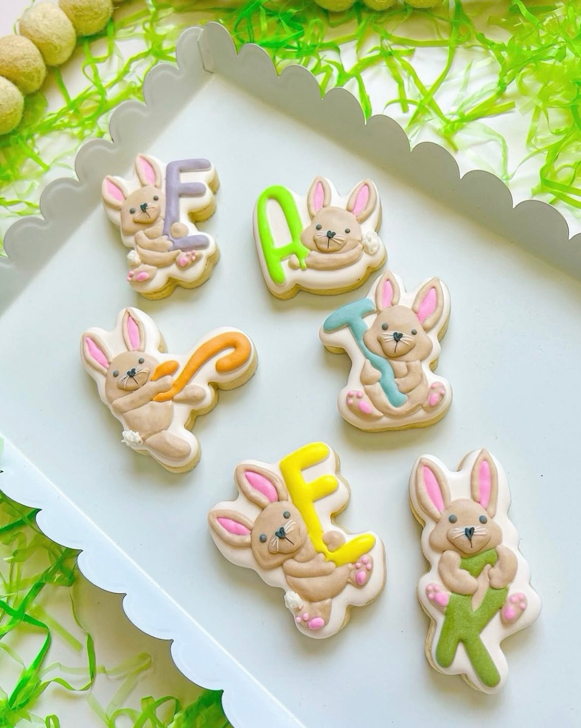 Playful bunnies holding E A S T E R letters stamp and cutter