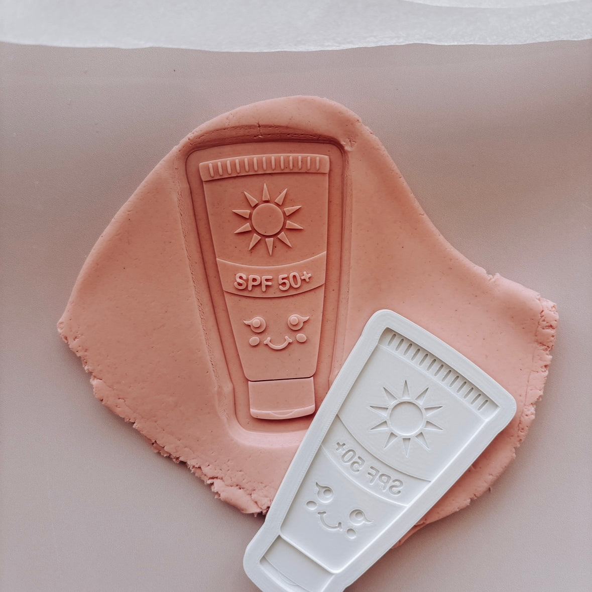Sunscreen SPF 50 with smiley face Debosser stamp and cutter