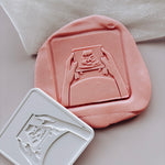 Hands holding baby scan photo stamp and cutter