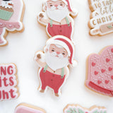 Santa Claus holding a cookie debosser and cutter
