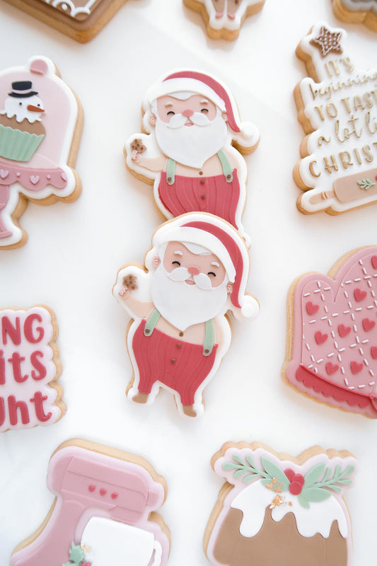 Santa Claus holding a cookie debosser and cutter