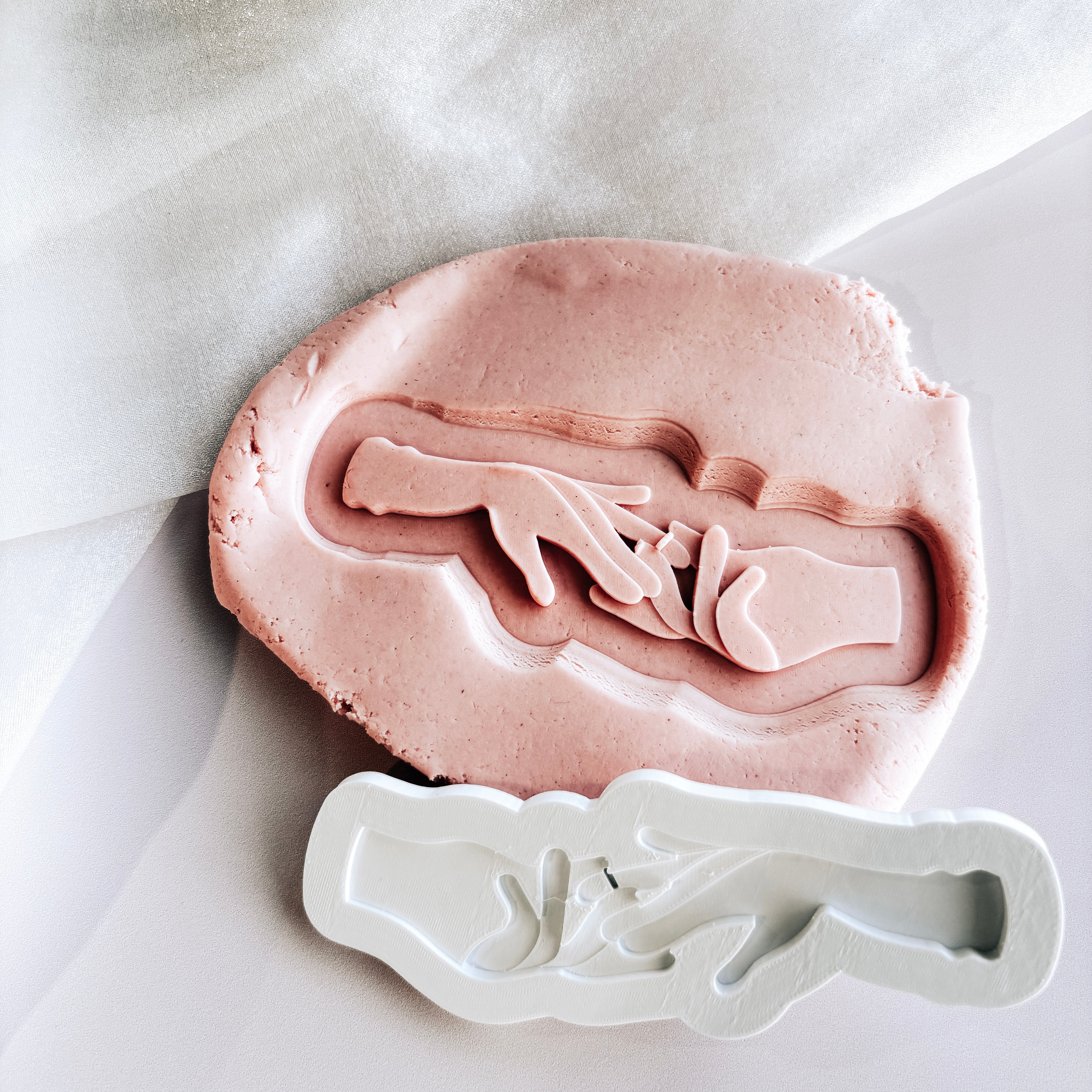 Hand placing ring on ring finger stamp and cutter