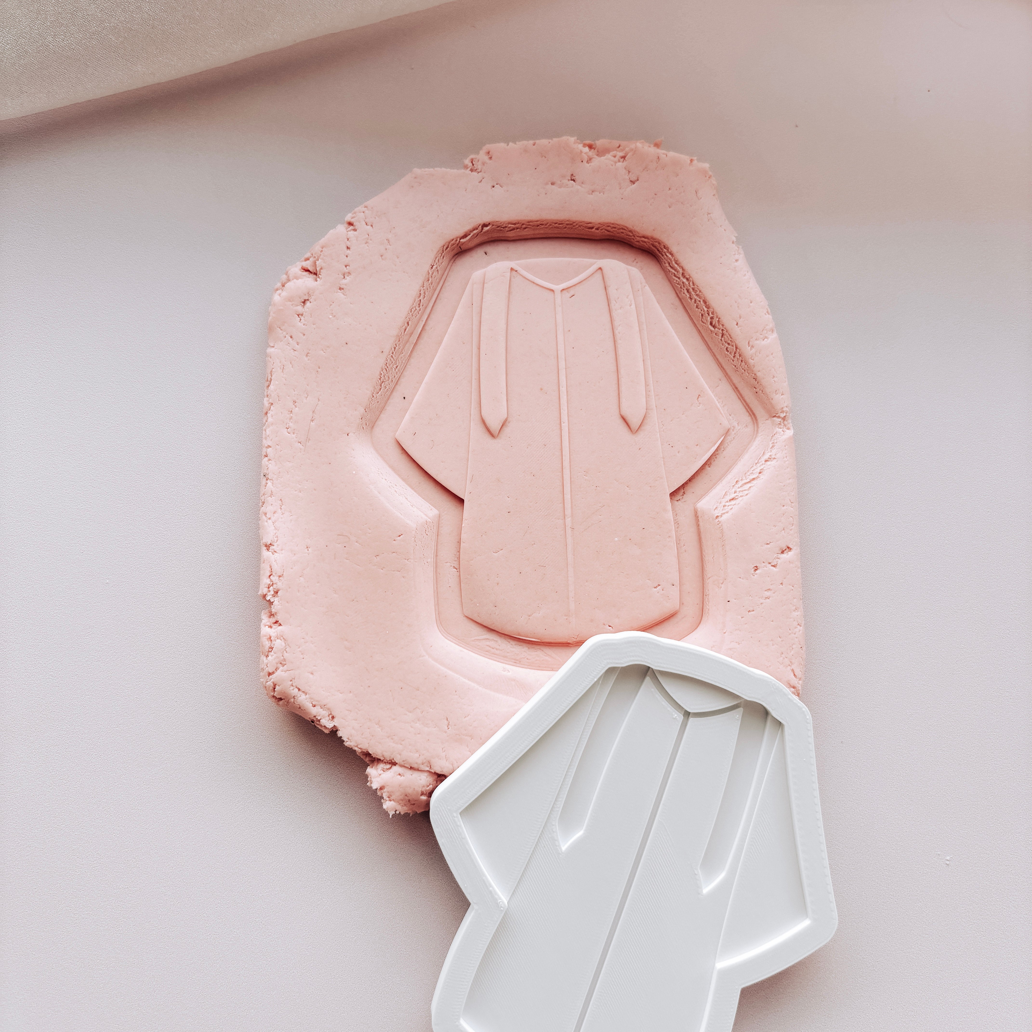 Graduation gown stamp and cutter