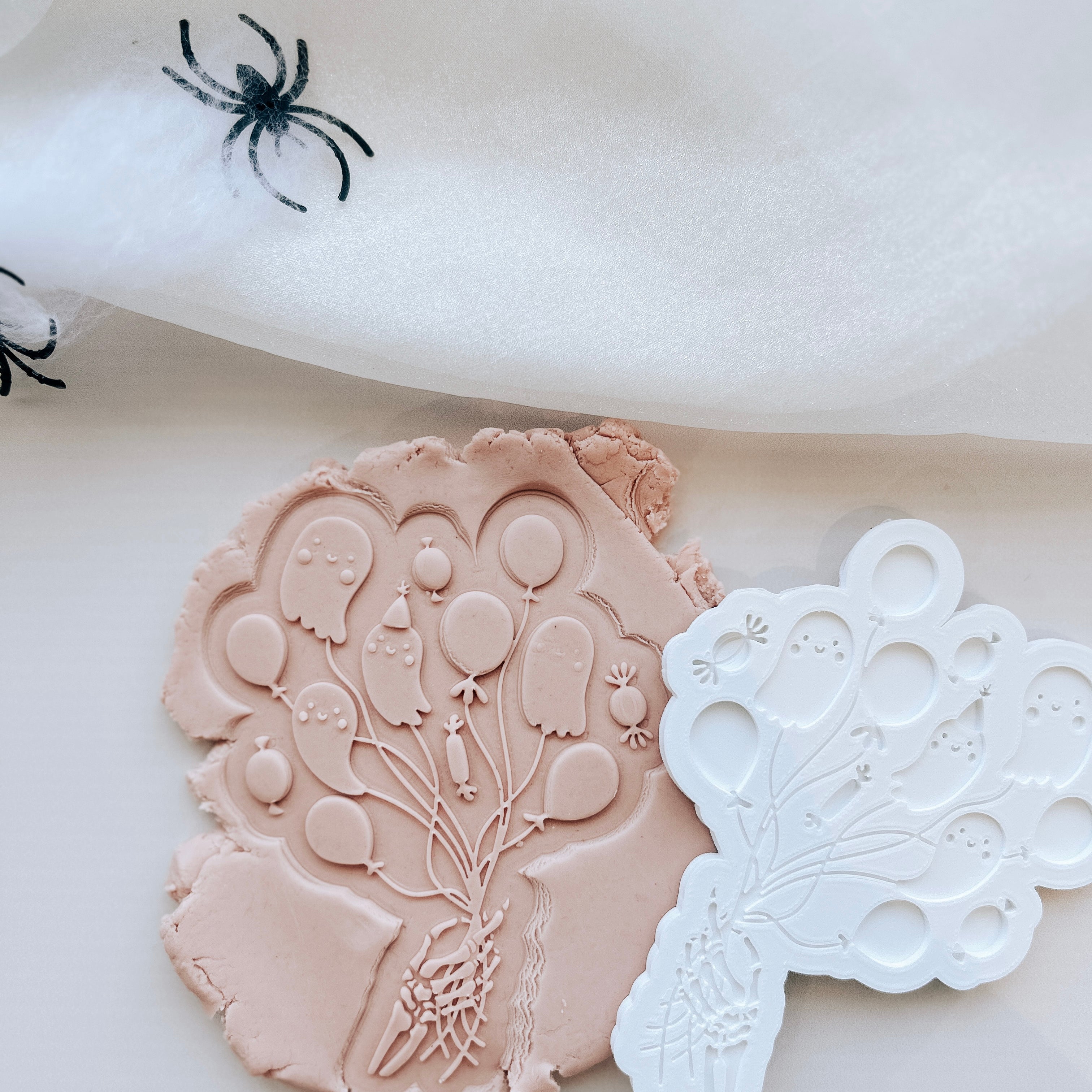 Skeleton hand holding the boo-loons debosser and cutter