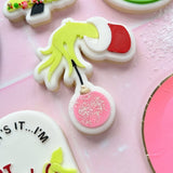 Grinch hand holding bauble stamp and cutter