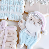 Santa Claus holding a cookie debosser and cutter